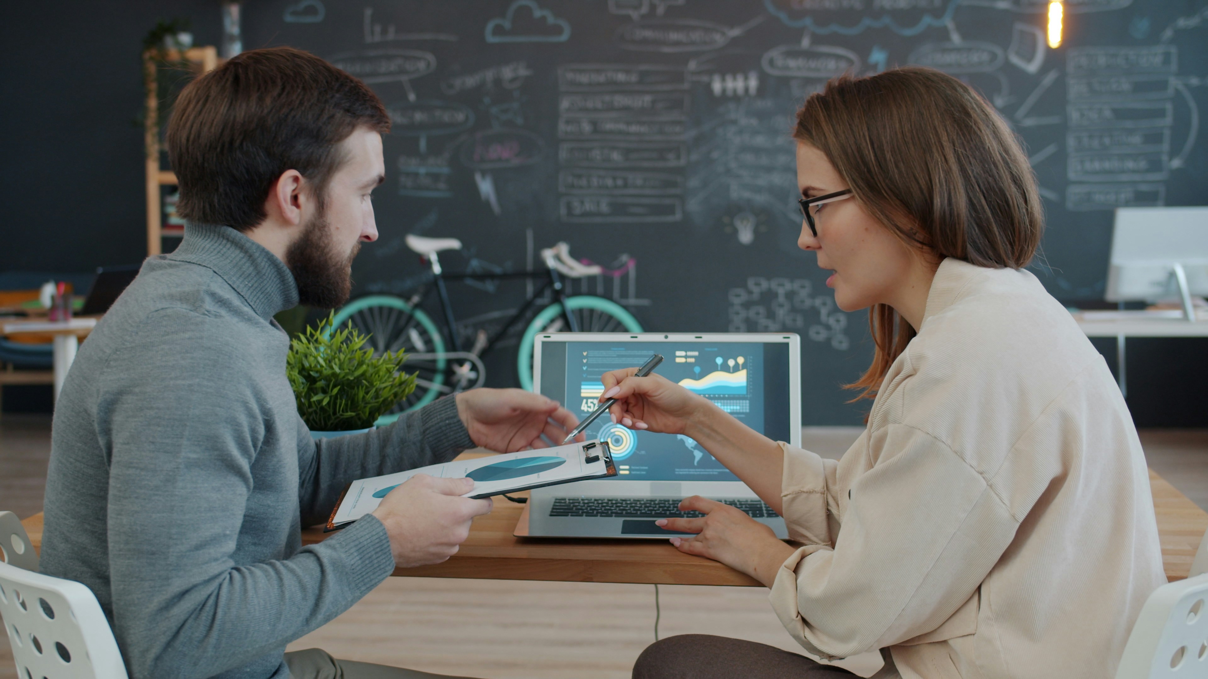 Dos colegas revisando datos en una computadora portátil